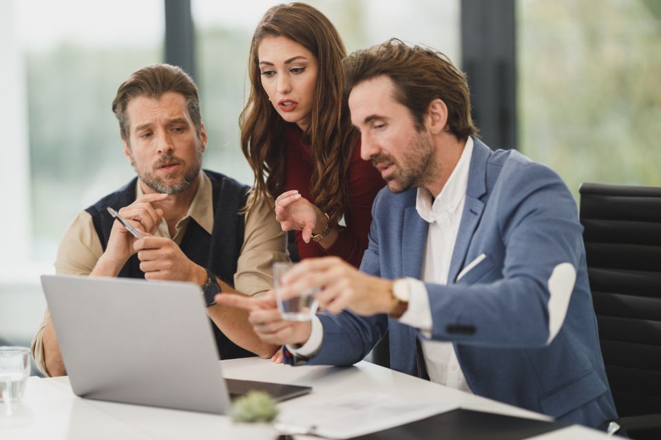 Tres profesionales revisando información con atención frente a una laptop